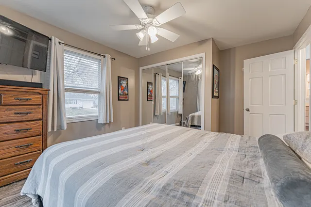 a bedroom with a large bed closet and flat screen tv