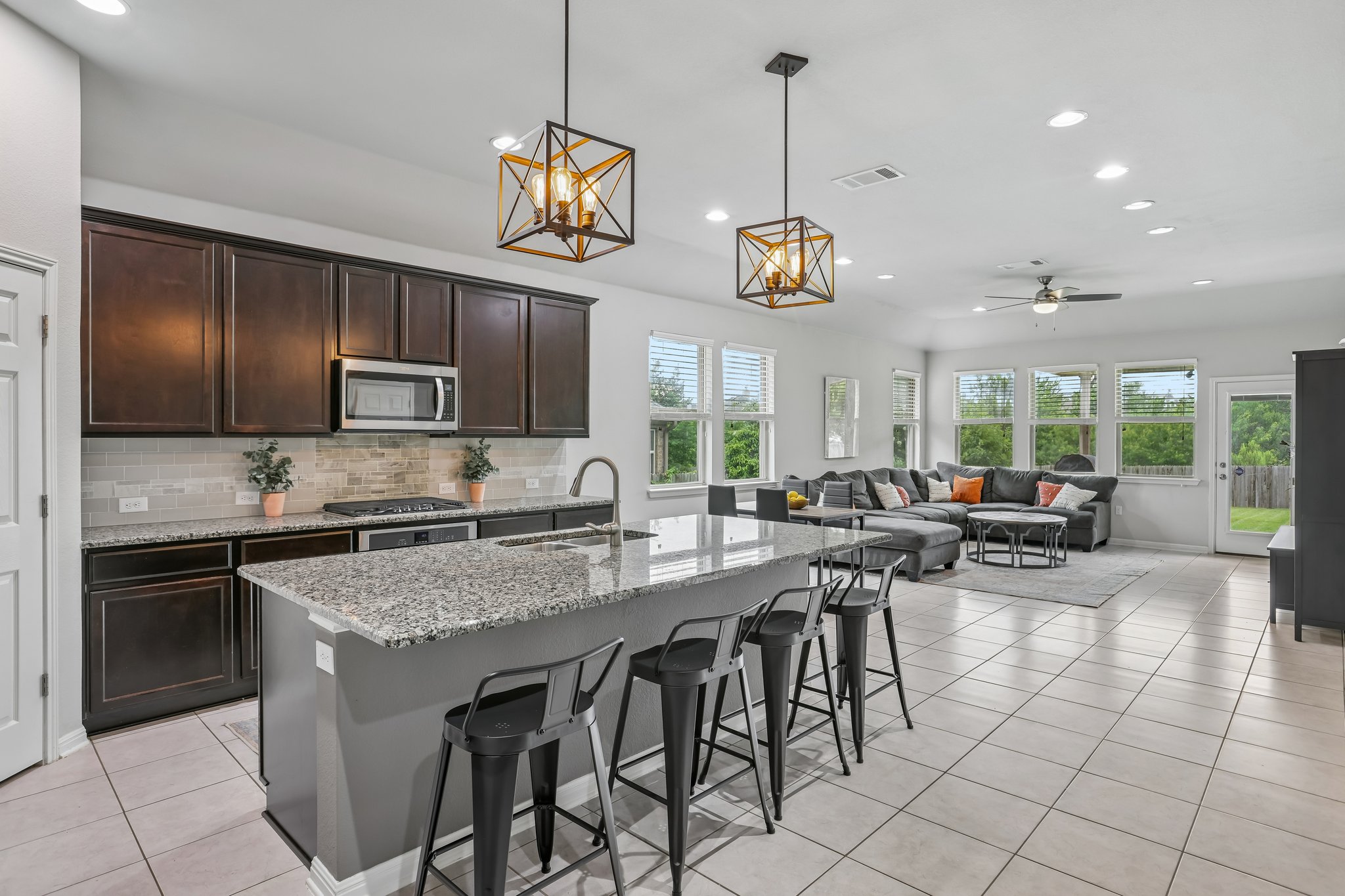 6801 Banff Cove Austin, TX 78754 - Photo 1 of 37 A contemporary kitchen with island with seating, flowing into a well-lit open family room