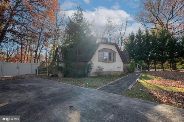 a view of a house with a yard and large tree