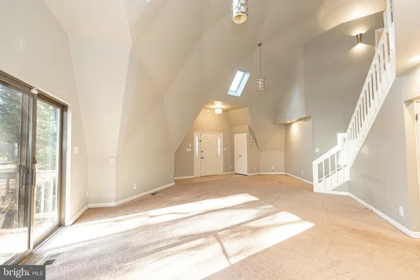 a view of a big room with wooden floor and windows