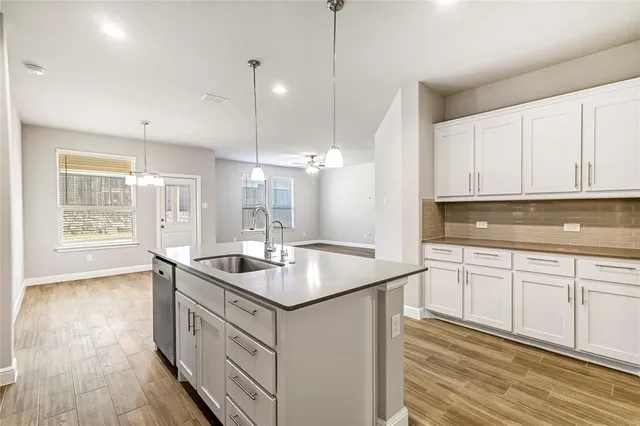 a kitchen that has a sink a stove and cabinets