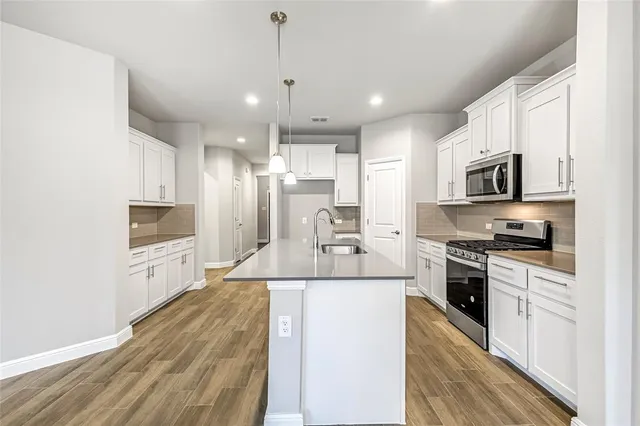 a kitchen with stainless steel appliances kitchen island granite countertop a sink and microwave