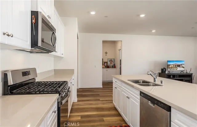 a kitchen with stainless steel appliances granite countertop a stove a sink and a microwave