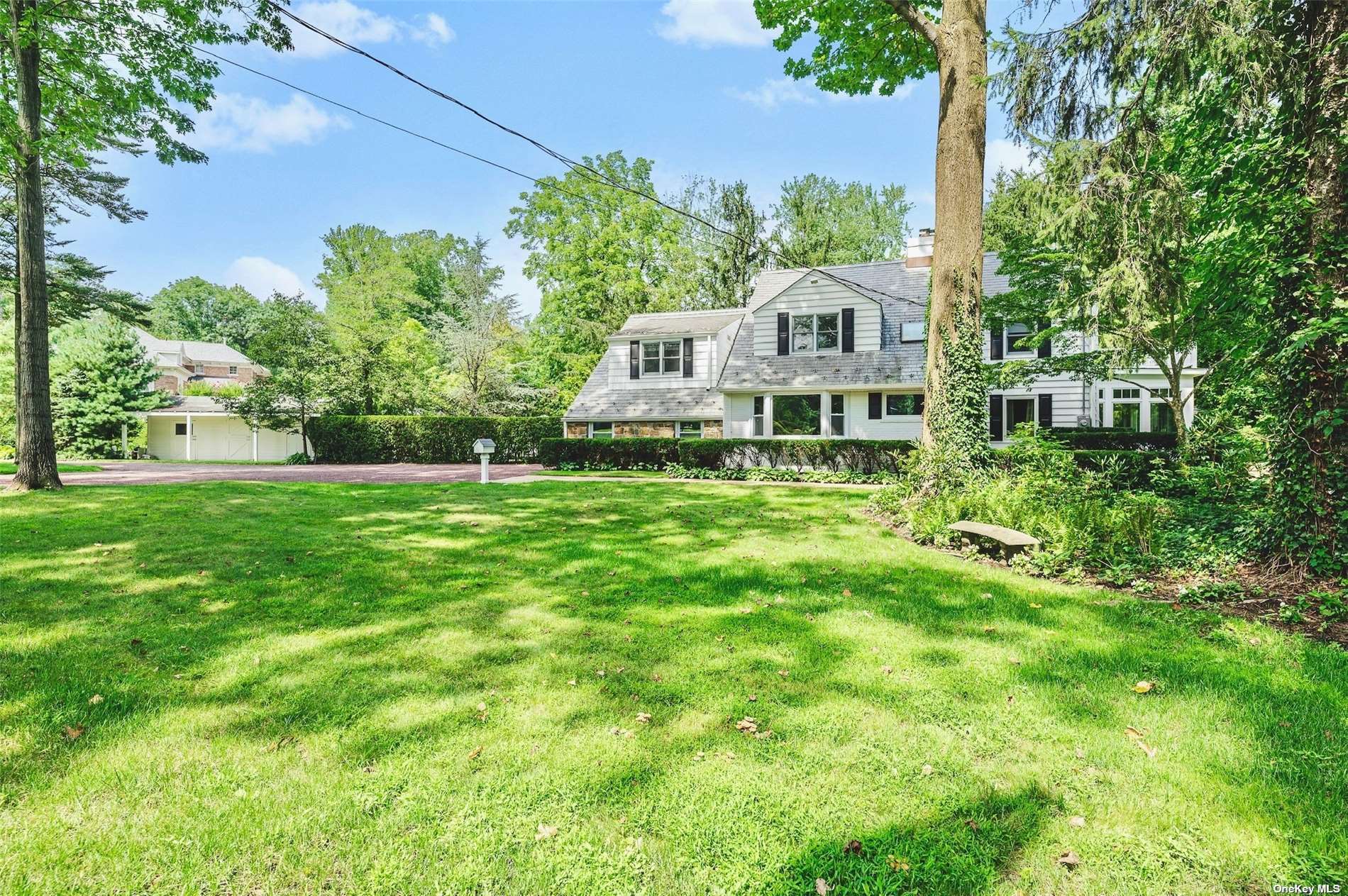 a view of a house with a big yard and large trees