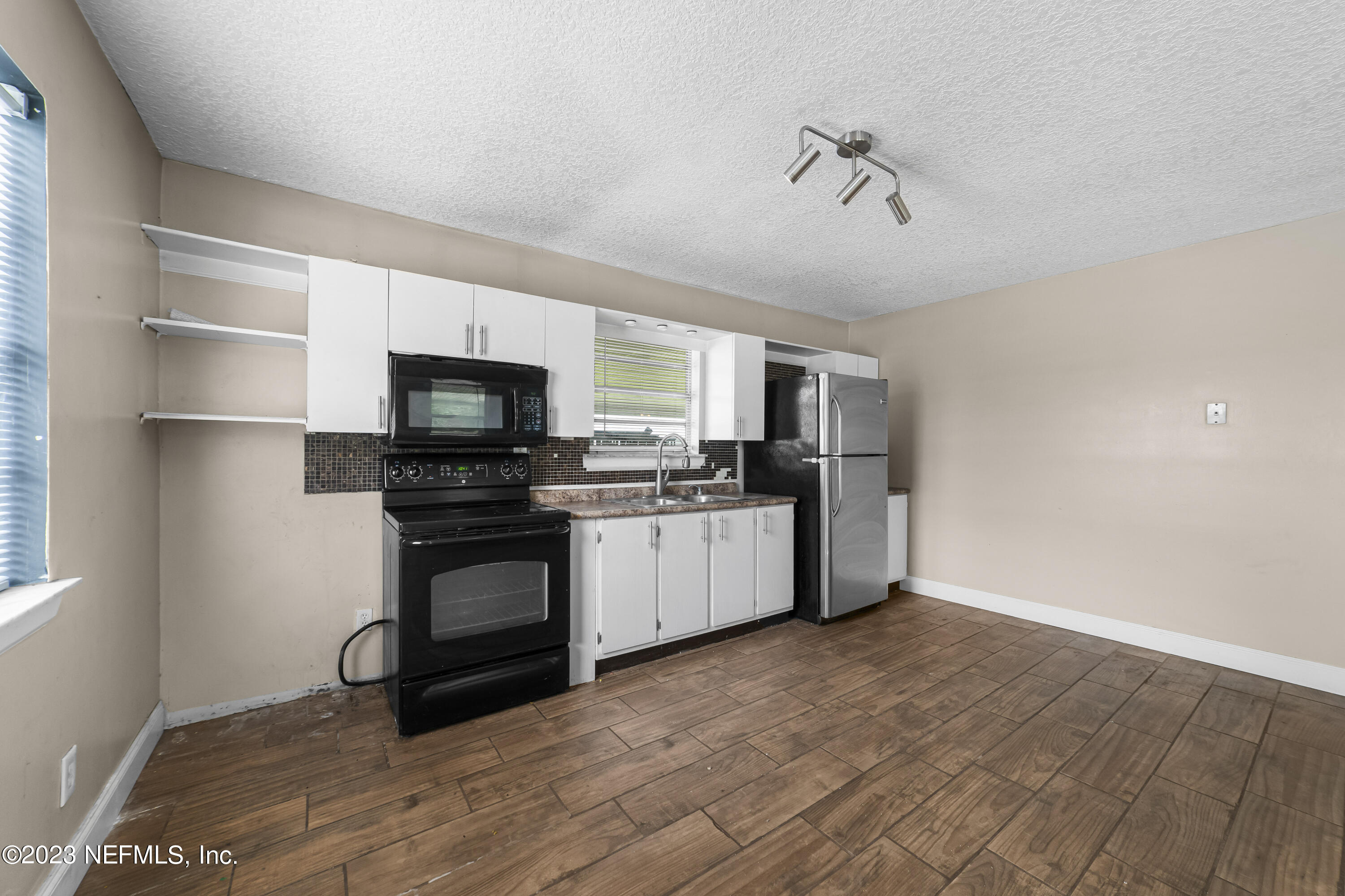 54412 Church Road Callahan, FL 32011 - Photo 36 of 47 a kitchen with stainless steel appliances a stove top oven a sink and a refrigerator
