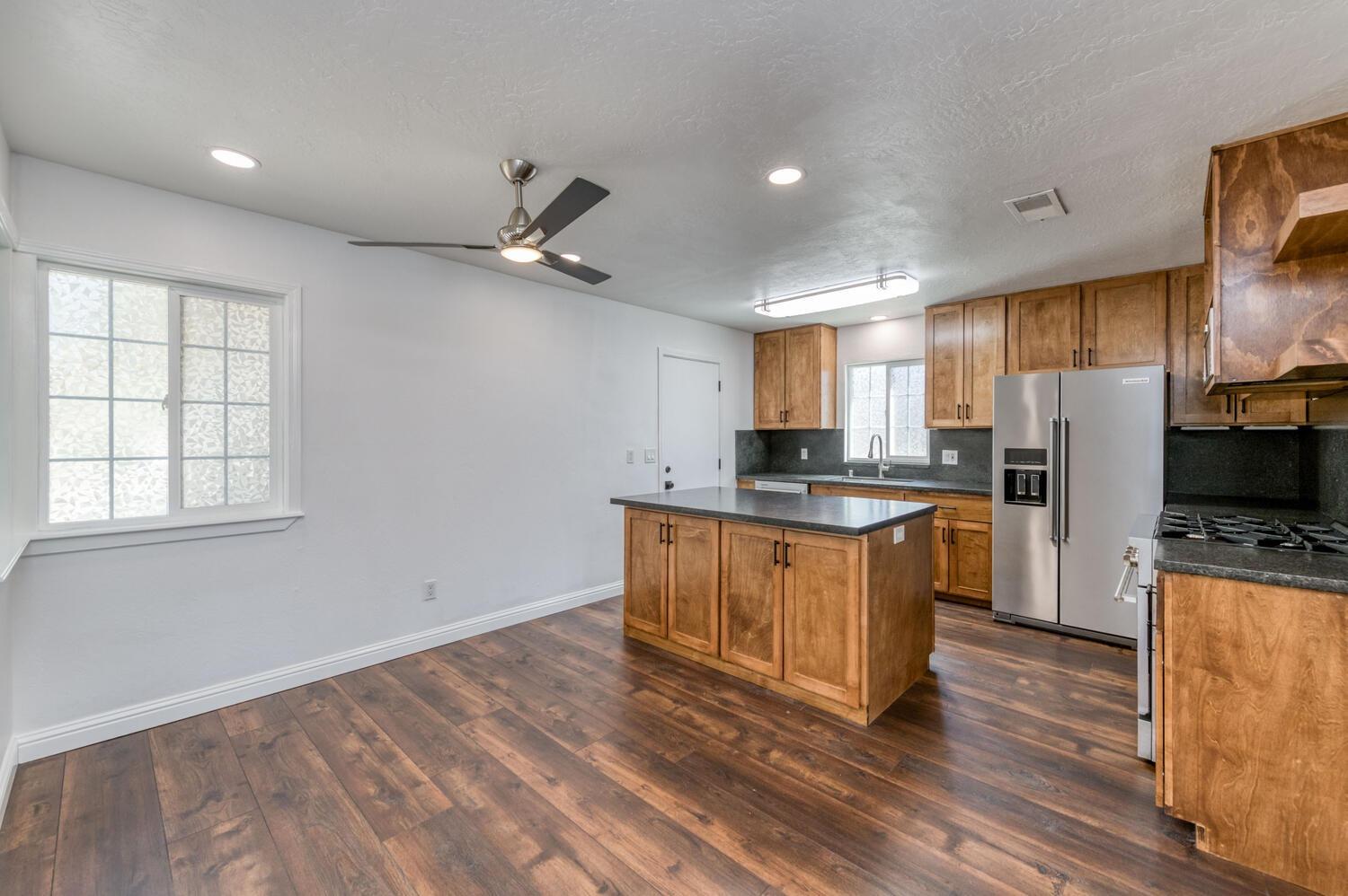 1626 Bliss Avenue Clovis, CA 93611 - Photo 12 of 31 a kitchen with stainless steel appliances granite countertop a refrigerator a sink dishwasher a stove with wooden cabinets and floor