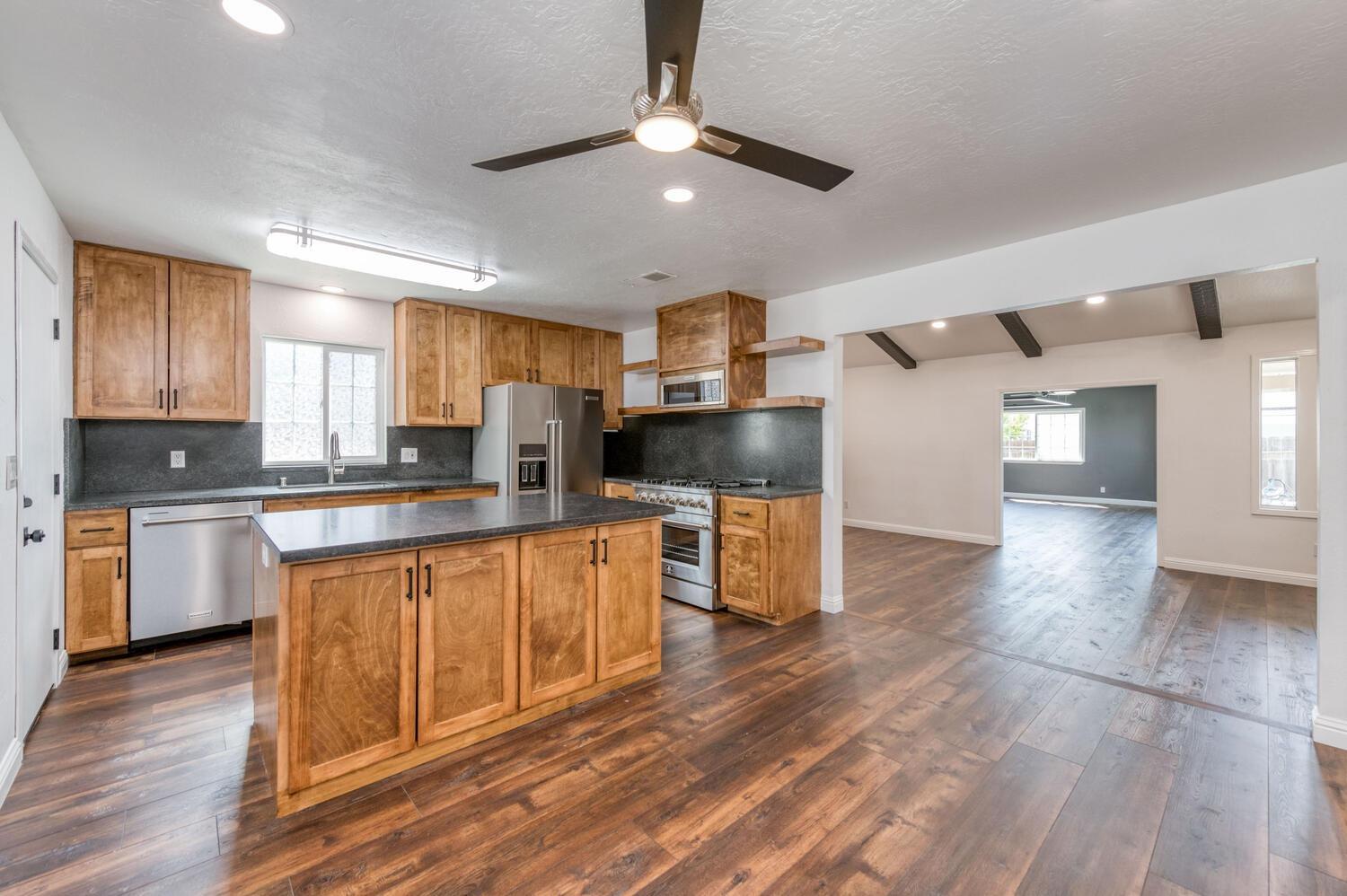1626 Bliss Avenue Clovis, CA 93611 - Photo 13 of 31 a kitchen with stainless steel appliances granite countertop a refrigerator a sink dishwasher a stove and white countertops with wooden floor