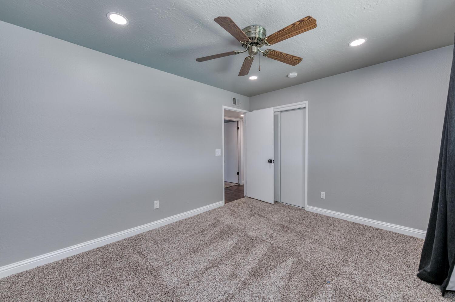 1626 Bliss Avenue Clovis, CA 93611 - Photo 22 of 31 an empty room with a ceiling fan and carpet