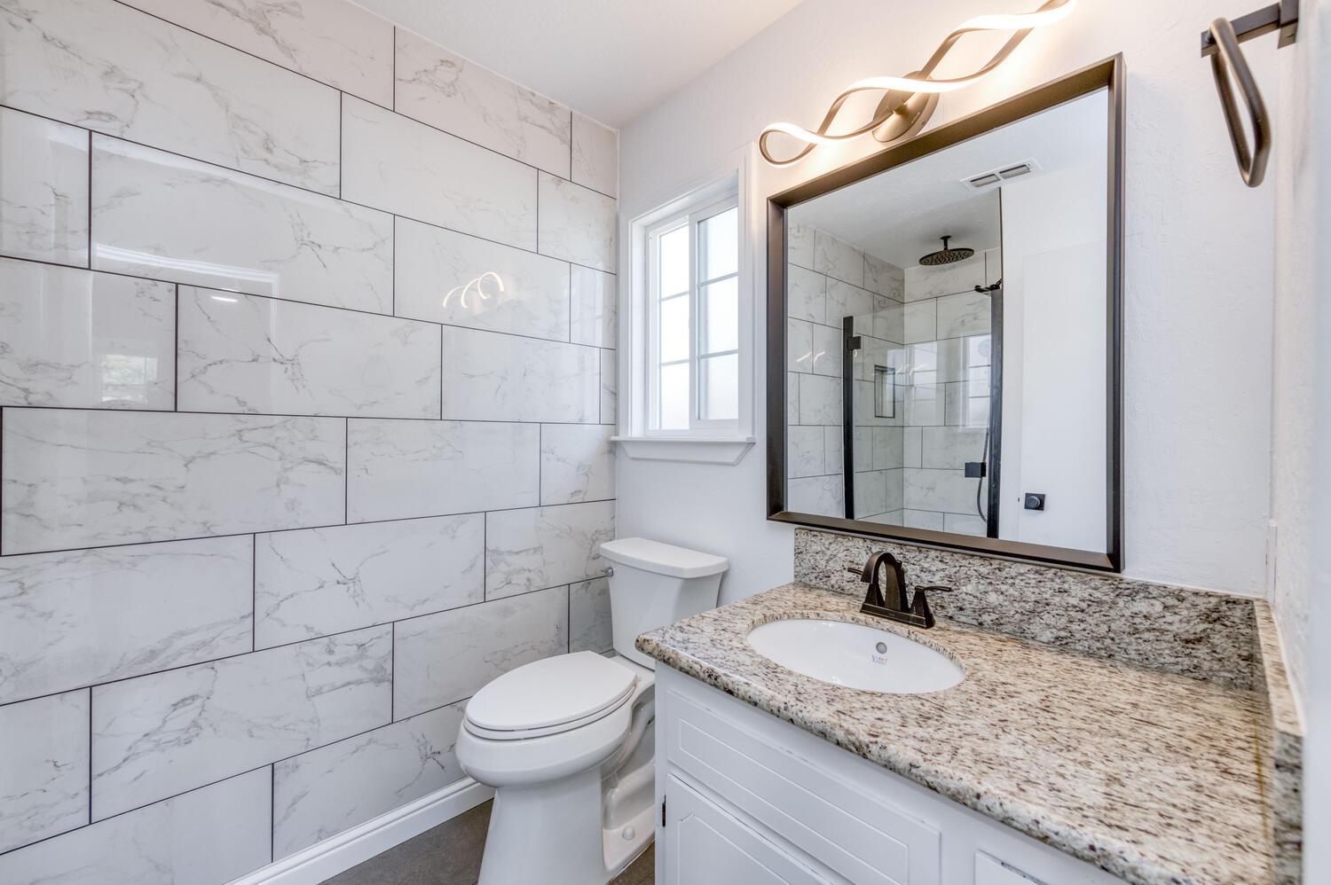 1626 Bliss Avenue Clovis, CA 93611 - Photo 25 of 31 a bathroom with a granite countertop sink a toilet and mirror