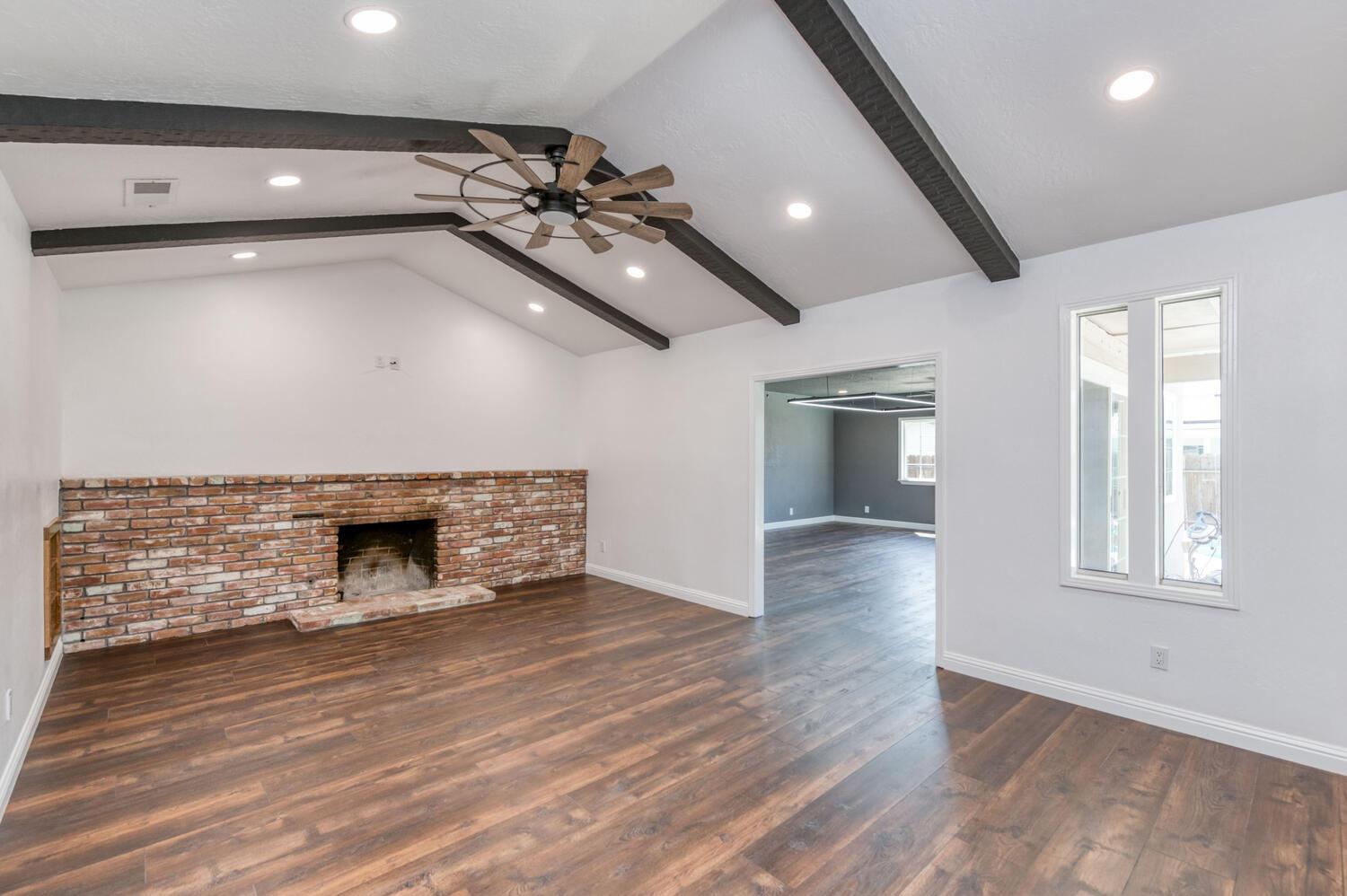 1626 Bliss Avenue Clovis, CA 93611 - Photo 4 of 31 an empty room with wooden floor fireplace and windows