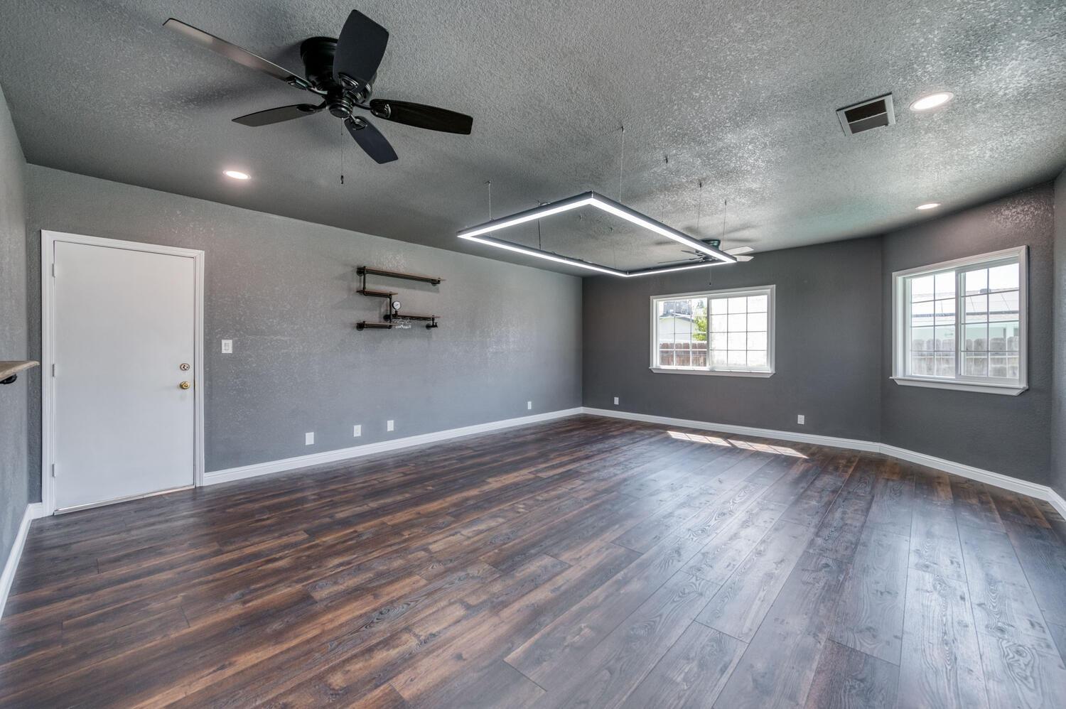 1626 Bliss Avenue Clovis, CA 93611 - Photo 8 of 31 a view of an empty room with wooden floor and a window