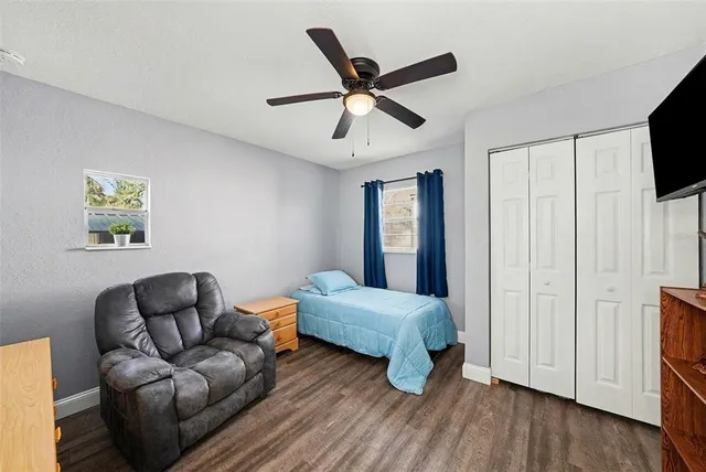 a living room with a bed furniture and a flat screen tv