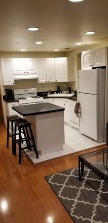 a room with stainless steel appliances kitchen island granite countertop a sink and stove