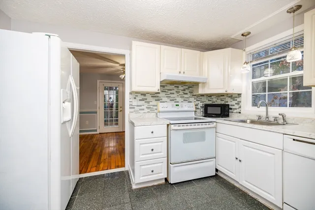 a kitchen with white cabinets and white appliances