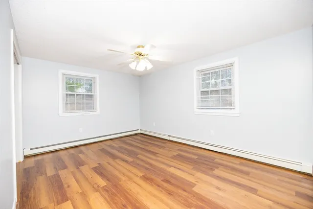 an empty room with wooden floor and window