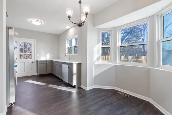 a view of a big room with wooden floor and windows