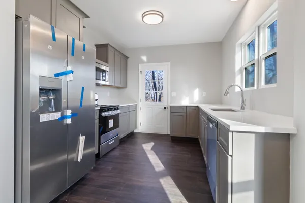 a kitchen with stainless steel appliances a sink a stove a refrigerator and cabinets