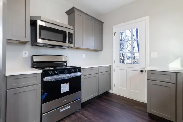 a kitchen with stainless steel appliances a stove microwave and sink
