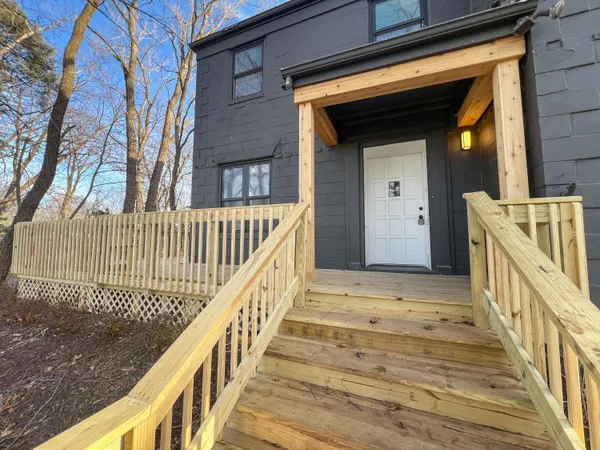 a view of staircase with railing and a rug