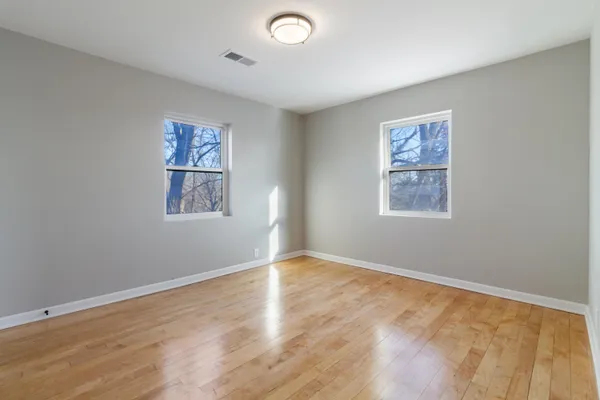 a view of an empty room with a window and a ceiling fan