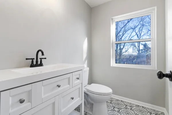a bathroom with a sink a toilet and a window