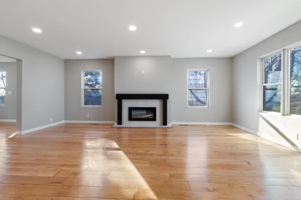 a view of an empty room with window and fire place