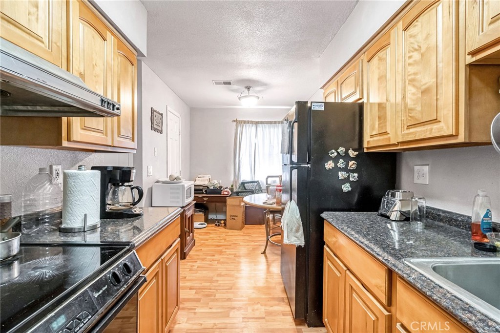 1624 B Street Fresno, CA 93706 - Photo 26 of 32 a kitchen with granite countertop a sink dishwasher stove and cabinets