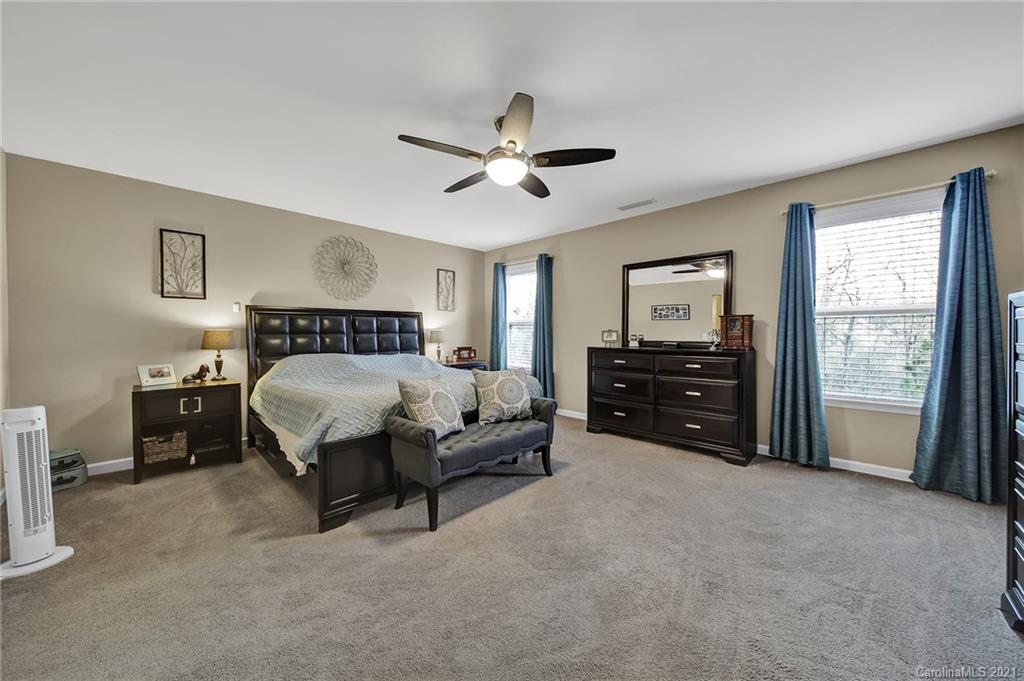 2162 Bluebell Way Tega Cay, SC 29708 - Photo 24 of 37 a spacious bedroom with a bed and a ceiling fan