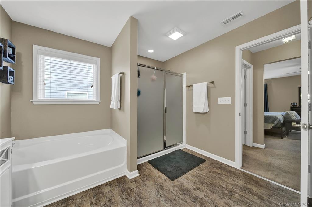 2162 Bluebell Way Tega Cay, SC 29708 - Photo 27 of 37 a bathroom with a tub a rug and a shower