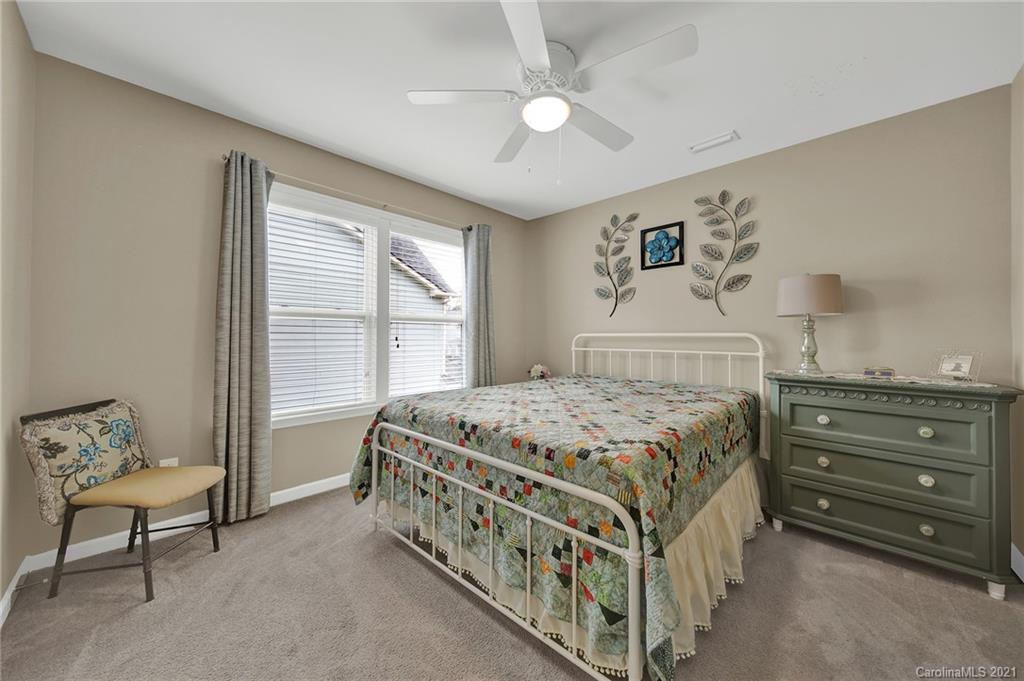 2162 Bluebell Way Tega Cay, SC 29708 - Photo 30 of 37 a bedroom with a bed a couch and a window