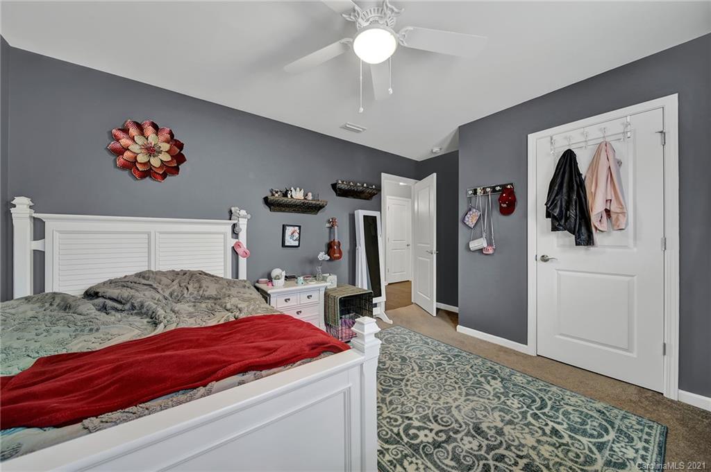 2162 Bluebell Way Tega Cay, SC 29708 - Photo 33 of 37 a bedroom with a bed and a chandelier