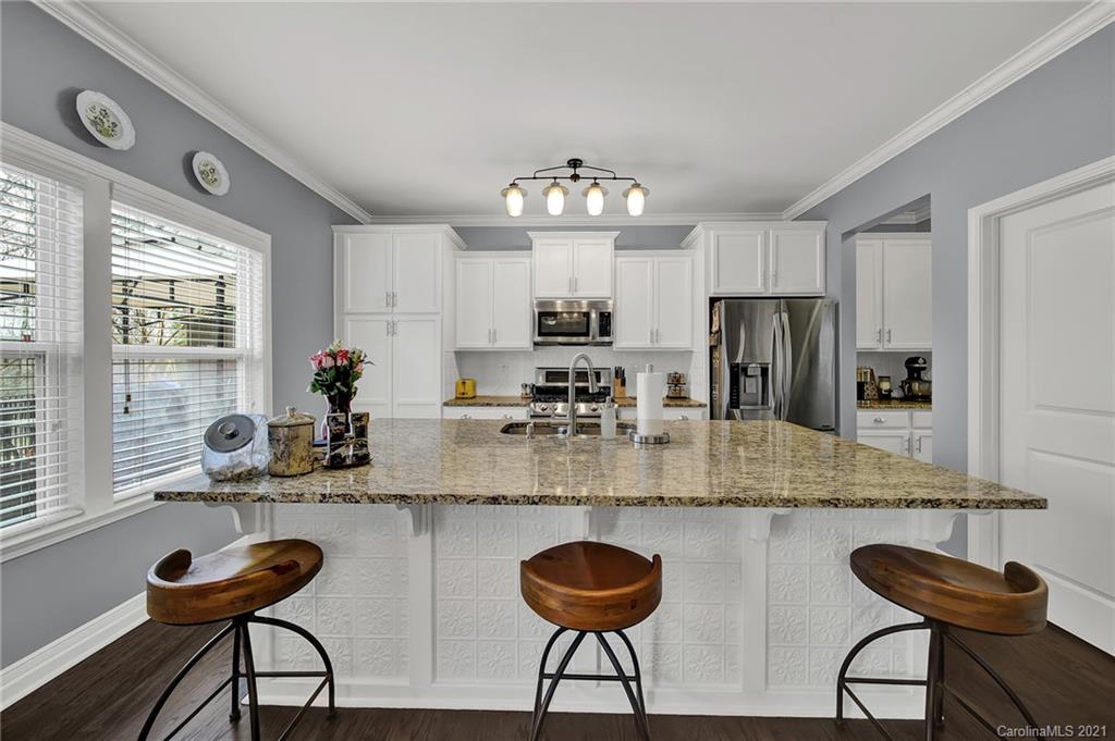 2162 Bluebell Way Tega Cay, SC 29708 - Photo 10 of 37 a kitchen with stainless steel appliances granite countertop a dining table chairs sink and cabinets