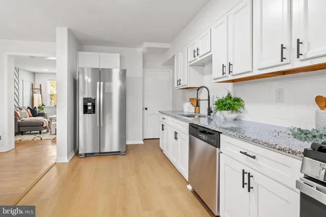 a kitchen with stainless steel appliances granite countertop a refrigerator and a stove top oven