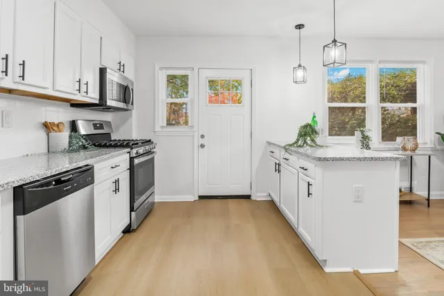 a kitchen with stainless steel appliances granite countertop a stove a sink and a refrigerator