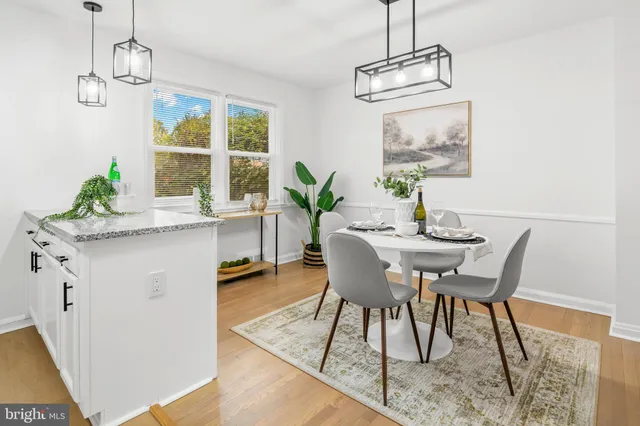 a dining room with wooden floor a chandelier a wooden table and chairs