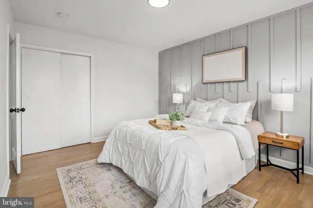 a bedroom with a bed and a lamp on dresser