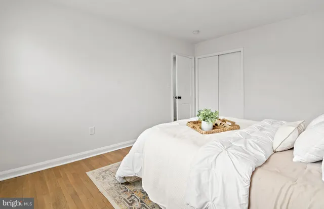 a bedroom with a bed and a wooden floor