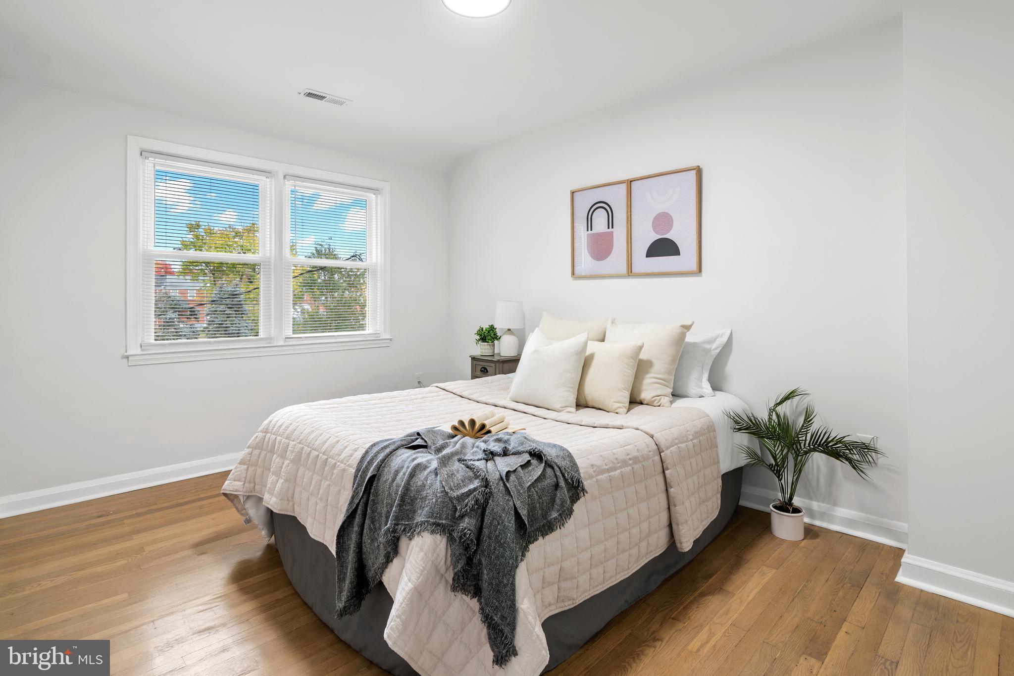 1212 Cedarcroft Road Baltimore, MD 21239 - Photo 26 of 42 a bed room with a bed and a potted plant