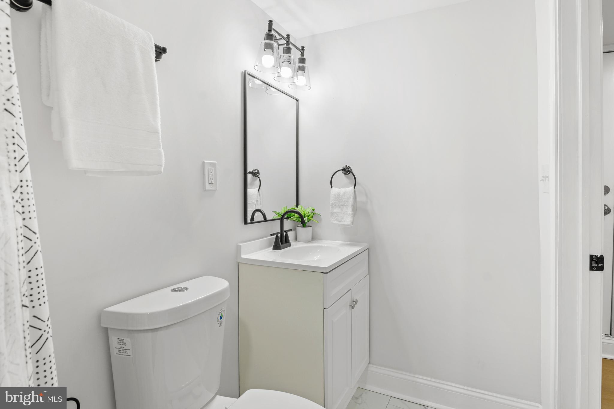 1212 Cedarcroft Road Baltimore, MD 21239 - Photo 36 of 42 a bathroom with a toilet sink and mirror