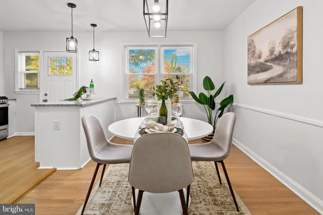 a dining room with furniture potted plants and wooden floor