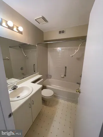 a bathroom with a granite countertop sink a toilet and shower