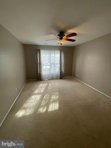 a view of a livingroom with a ceiling fan and window