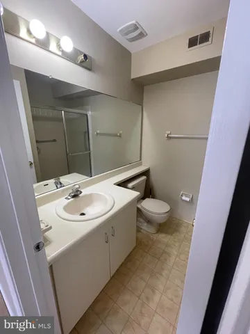 a bathroom with a sink a toilet a mirror and vanity