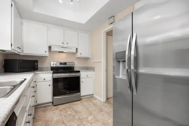 a kitchen with stainless steel appliances a refrigerator sink and cabinets