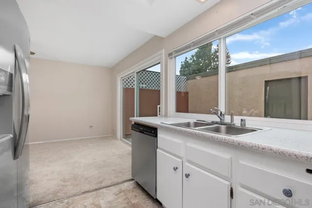 a kitchen with granite countertop a sink and a refrigerator