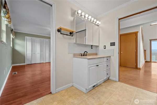 a view of a kitchen with cabinets and wooden floor