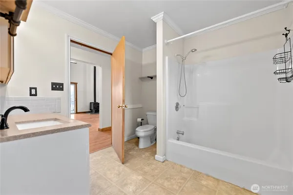 a bathroom with a sink a toilet and shower