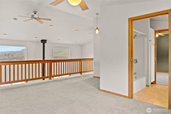 a view of a hallway with a chandelier fan and windows
