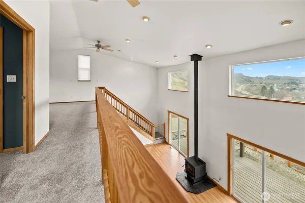 a view of hallway with stairs and wooden floor
