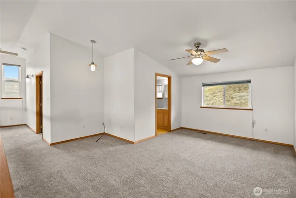an empty room with a window and a ceiling fan